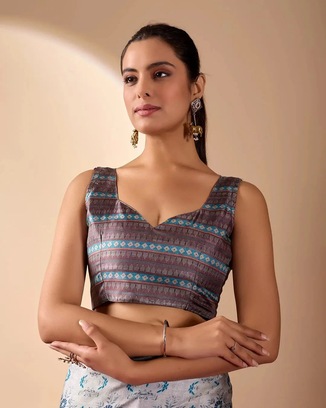 Woman wearing a patterned top with a plain background